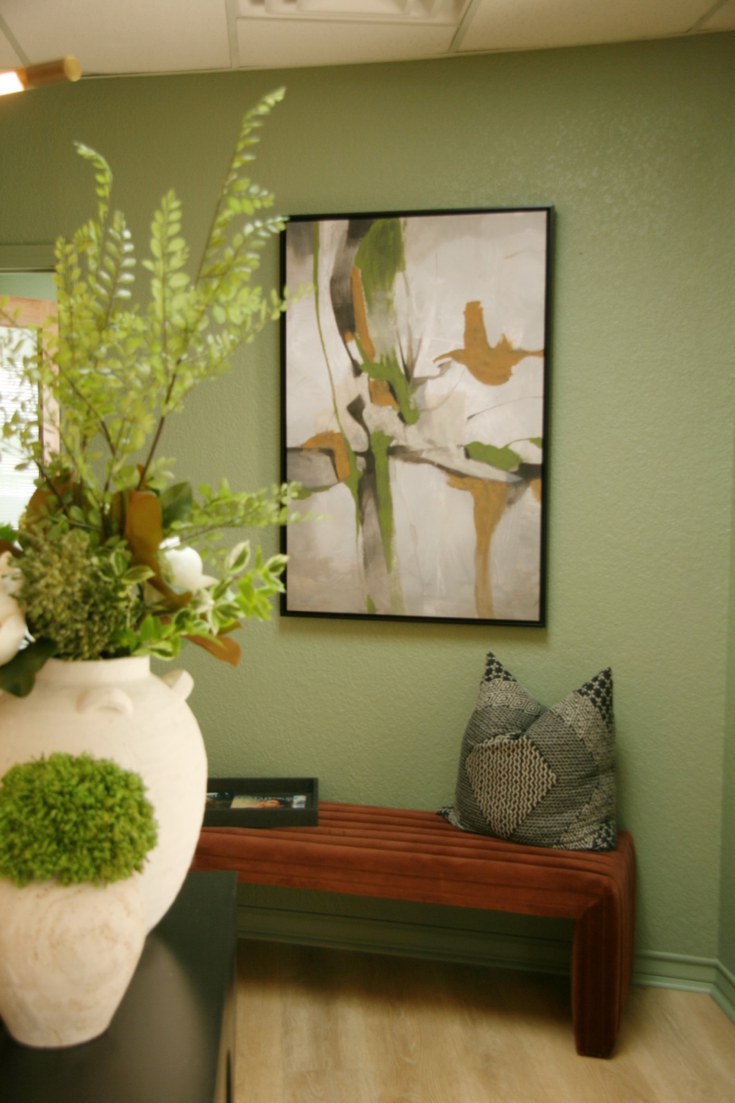 Editorial vignette of the entry bench beneath the art at Bespoke